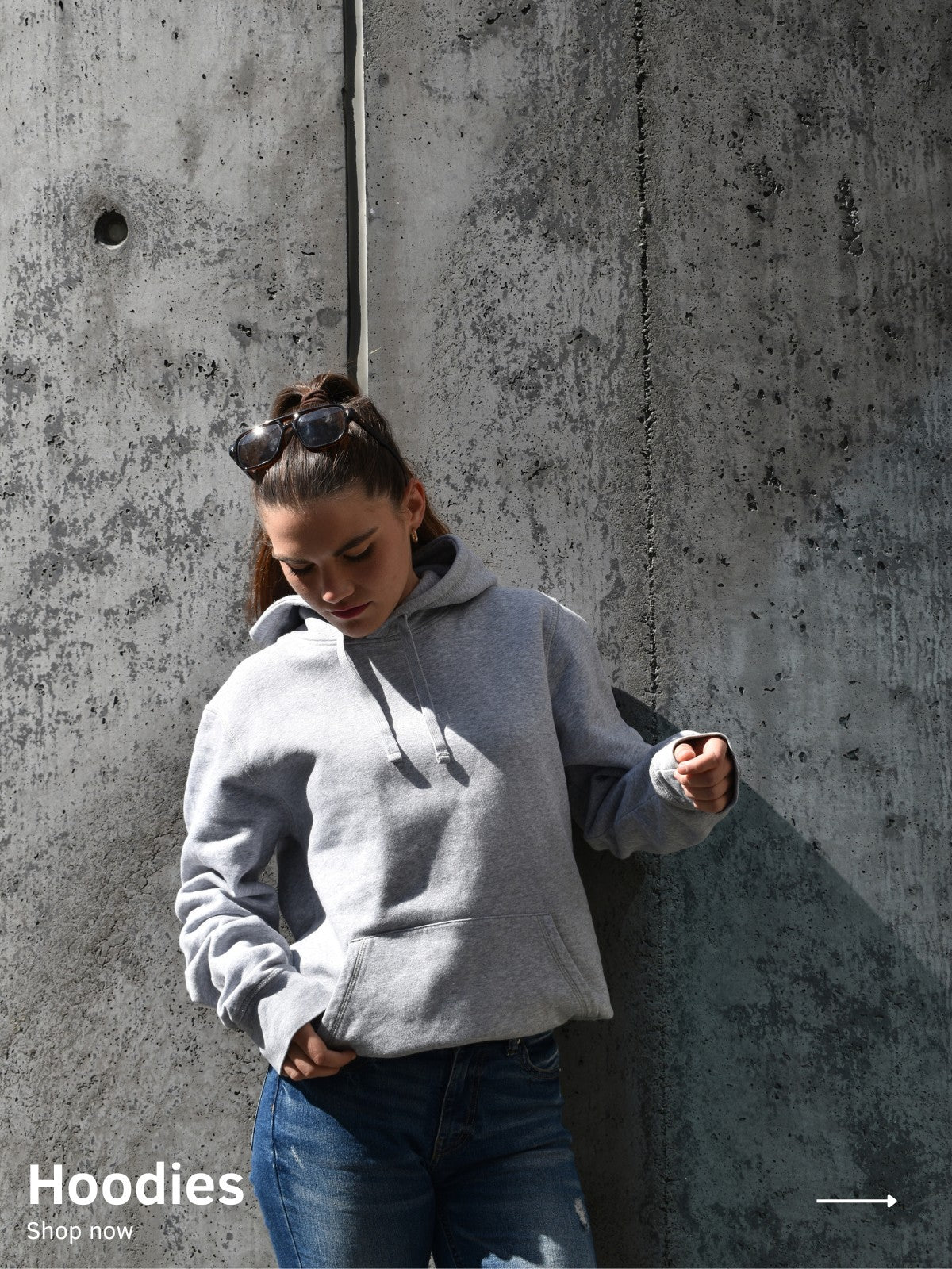 Eine Frau trägt einen grauen Oversized Hoodie mit weißem unfgtble Schriftzug